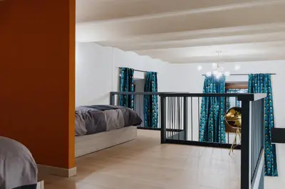 a bedroom with a bed and blue curtains at Modern loft in central Rome in Rome