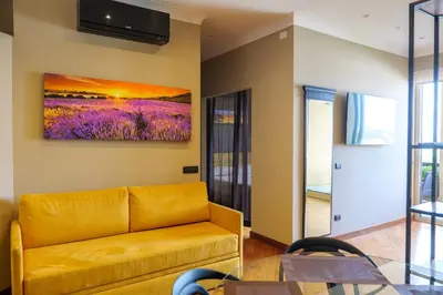 a living room with a couch and a painting on the wall at Domus Aurelia Luxury in Rome