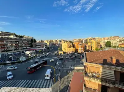 a busy city street with buses and cars on a street at Roma Battistini 66 Apartment, near Vatican City in Rome