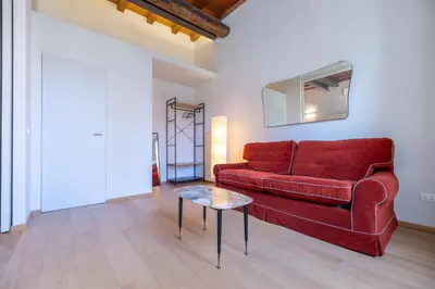 a living room with a red couch and a table at Titta's Dream by BuddyRent in Rome