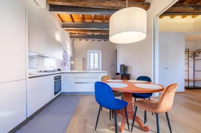 a kitchen with a wooden table and blue chairs at Titta's Dream by BuddyRent in Rome