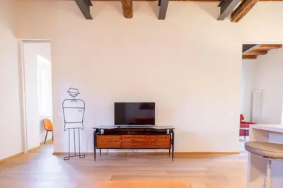 a living room with a tv and a man drawn on the wall at Titta's Dream by BuddyRent in Rome