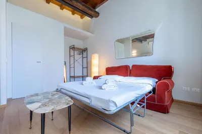 a room with a bed and a red couch at Titta's Dream by BuddyRent in Rome