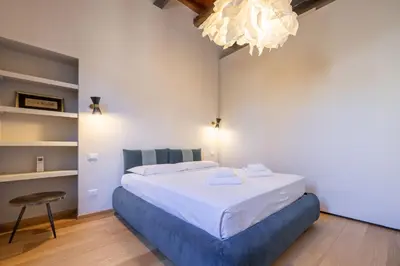 a bedroom with a bed and a chandelier at Titta's Dream by BuddyRent in Rome