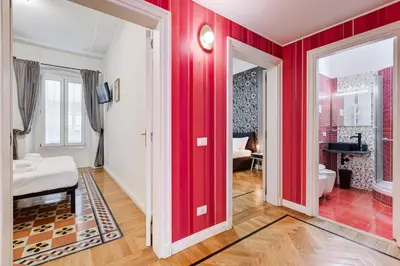 a room with red walls and a bedroom with a bed at Salotto Trastevere in Rome