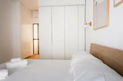 a bedroom with a white bed with white sheets at Residenza Lungotevere dei Mellini in Rome