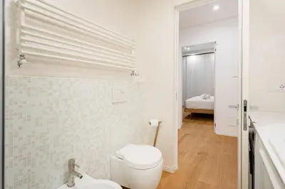 a white bathroom with a toilet and a sink at Residenza Lungotevere dei Mellini in Rome