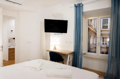 a bedroom with a desk and a bed and a window at Residenza Lungotevere dei Mellini in Rome