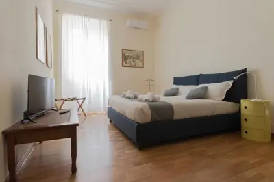 a bedroom with a bed and a television and a table at Domus 1886 (Quartiere Prati) in Rome