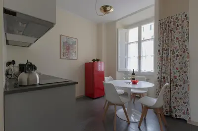 a kitchen with a white table and a red refrigerator at Domus 1886 (Quartiere Prati) in Rome