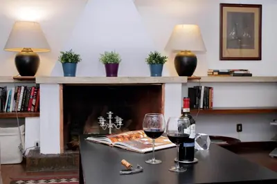 a table with two glasses of wine and a fireplace at Benedetta21 in Rome