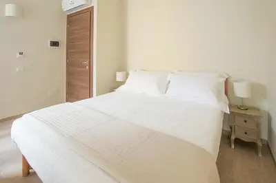 a bedroom with a large white bed with a night stand at Trastevere Chic in Rome