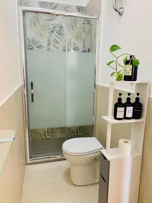 a bathroom with a toilet and a glass shower at Il Nido apartment Roma, Attico ostiense in Rome
