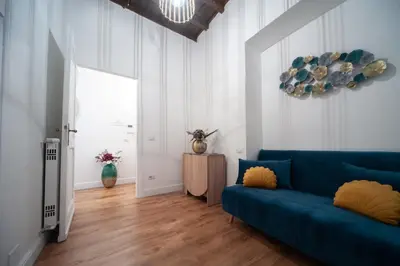 a living room with a blue couch and a window at Pantheon Charming Accommodation in Rome