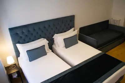 a bedroom with two beds and a couch at Michelangelo Vatican Rooms in Rome