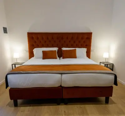 a bedroom with a large bed with two pillows at Michelangelo Vatican Rooms in Rome