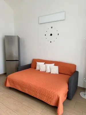 a bed with two pillows and a clock on the wall at Betterplace in Rome