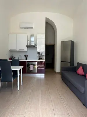 a living room with a couch and a table and a kitchen at Betterplace in Rome
