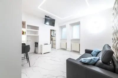 a living room with a black couch and a tv at Casa Cate in Rome