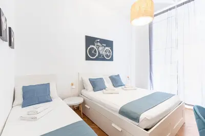 a bedroom with two beds and a bike picture on the wall at Hostly - Michelangelo Suite Midtown-Center of Rome in Rome