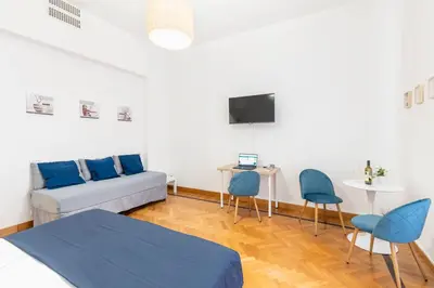 a living room with a couch and a table and chairs at Hostly - Michelangelo Suite Midtown-Center of Rome in Rome