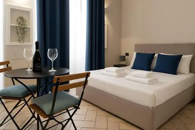 a bedroom with a bed and a table and chairs at èROMA - COLOSSEO Apartment in Rome