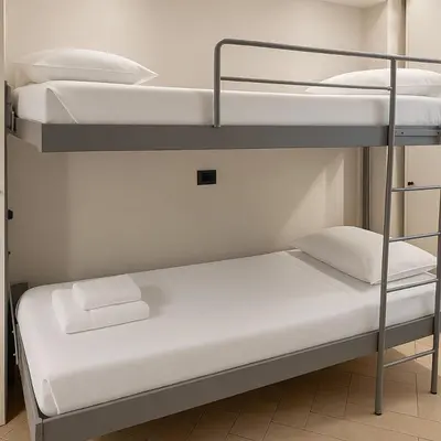 a room with two bunk beds with white pillows at èROMA - COLOSSEO Apartment in Rome