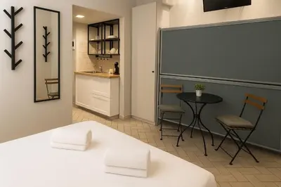 a room with a table and chairs and a kitchen at èROMA - COLOSSEO Apartment in Rome