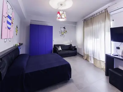 a bedroom with a blue bed and a couch at Affittacamere Tiburstation 2 in Rome