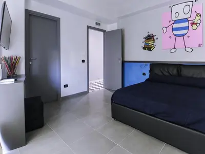 a bedroom with a black bed and a wall with drawings on it at Affittacamere Tiburstation 2 in Rome