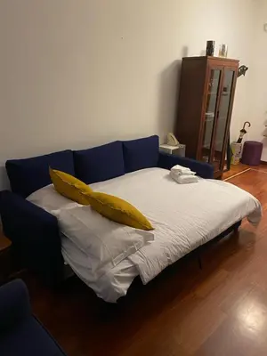 a blue couch with a yellow pillow on it at Villa Borghese Domus in Rome