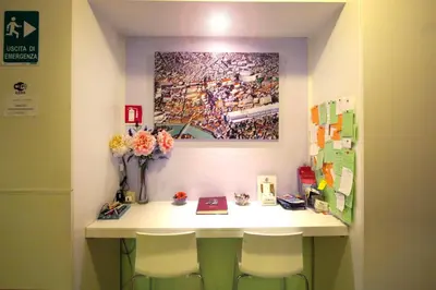 a room with a desk with two chairs and a painting at Colosseoinn in Rome