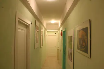 a hallway with green and white walls and a white door at Colosseoinn in Rome