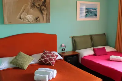 two beds sitting next to each other in a room at Colosseoinn in Rome