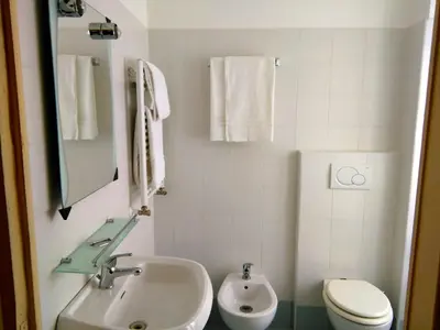 a white bathroom with a sink and a toilet at Colosseoinn in Rome