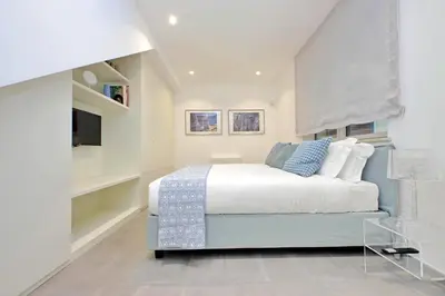 a white bedroom with a bed and a tv at YCH-Casa Indipendente in zona Prati in Rome