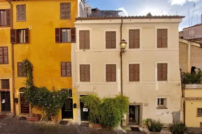 a large white building with brown shuttered windows at Monti Studio in Rome