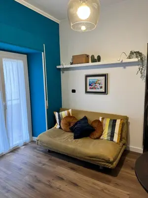 a couch in a living room with a blue wall at Civico Nove al Colosseo in Rome