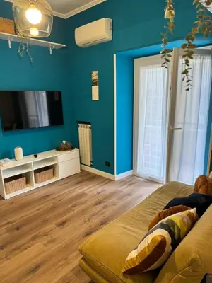 a living room with blue walls and a television at Civico Nove al Colosseo in Rome