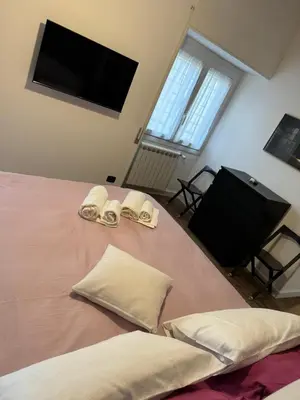 a bedroom with a bed with pillows and a flat screen tv at Civico Nove al Colosseo in Rome