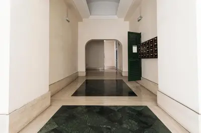 a hallway with white walls and wood floors and a wine cellar at Studio Margherita in Rome