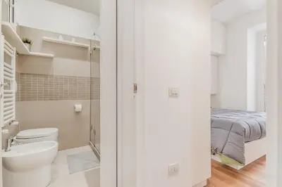 a bathroom with a toilet and a bed at Trastevere House 24 in Rome