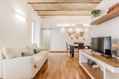 a living room with a white couch and a flat screen tv at Trastevere House 24 in Rome