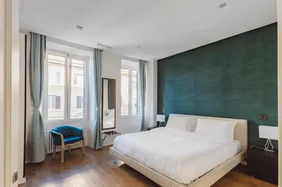 a bedroom with a large bed and a green wall at The Place Giuliana in Rome