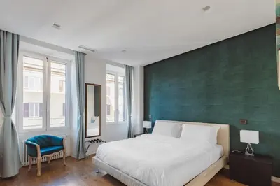 a bedroom with a large bed and a green wall at The Place Giuliana in Rome