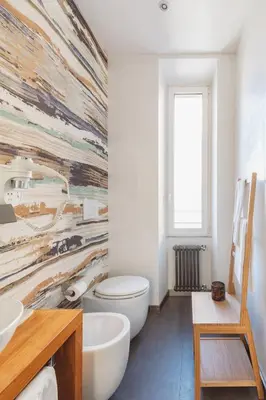 a bathroom with a toilet and a large mural on the wall at The Place Giuliana in Rome