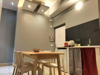 a kitchen with a wooden table and chairs at OLD BAKERY TWO BED ROOM APARTMENT in Rome