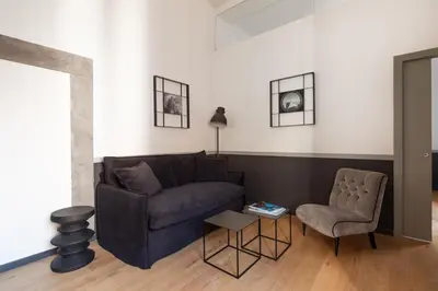 a living room with a couch and a chair at Trastevere Charming Rosa Apartment in Rome