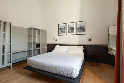 a bedroom with a white bed and some shelves at Trastevere Charming Rosa Apartment in Rome