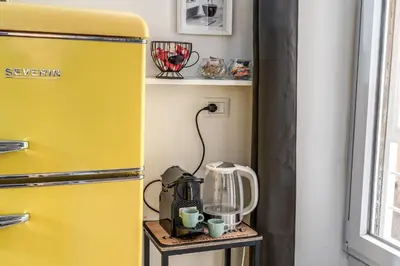 a yellow refrigerator next to a table with a blender at Kira Luxury Apartment with terrace in Rome